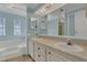 Bright bathroom with double vanity, large mirror, and soaking tub beneath a decorative window at 119 Jana Cir, Auburndale, FL 33823
