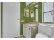 Practical bathroom featuring toilet, sink, and door with green-painted wall at 119 Jana Cir, Auburndale, FL 33823