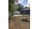 Backyard with a fire pit, shed, and concrete pavers leading to the screened-in porch at 1250 Lemonwood Ave, Deland, FL 32724