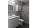 Bathroom with gray walls, vanity, and a shower with gray and black design at 1250 Lemonwood Ave, Deland, FL 32724