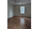 Bright bedroom with light hardwood floors, a ceiling fan, and a window overlooking the backyard at 1250 Lemonwood Ave, Deland, FL 32724