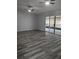 Spacious living room with hardwood floors, ceiling fans, and sliding glass doors to the lanai at 1250 Lemonwood Ave, Deland, FL 32724