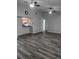 Open-concept living room with hardwood floors, ceiling fans, and a view of the kitchen at 1250 Lemonwood Ave, Deland, FL 32724