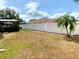 Fenced backyard with partial grass, tropical tree, and screened-in patio at 1311 Fallwood Dr, Deltona, FL 32725