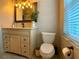 This is a bathroom with an oak vanity, granite countertop, and a modern lighting fixture at 1311 Fallwood Dr, Deltona, FL 32725
