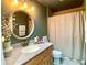 This is a bathroom with an oak vanity, granite countertop, and a shower curtain at 1311 Fallwood Dr, Deltona, FL 32725
