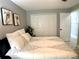 Bedroom featuring a queen bed with a black and white comforter, white closet doors and light gray walls at 1311 Fallwood Dr, Deltona, FL 32725