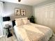 Comfortable bedroom featuring a queen bed with a black and white comforter and white closet doors at 1311 Fallwood Dr, Deltona, FL 32725