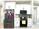 Close-up of kitchen with stainless refrigerator, microwave, gray backsplash, and white cabinets at 1311 Fallwood Dr, Deltona, FL 32725