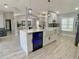 Kitchen island with a beverage refrigerator, farmhouse sink, and pendant lighting at 1311 Fallwood Dr, Deltona, FL 32725