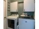 Laundry room with washer, dryer, and wall-mounted cabinets for added storage at 1311 Fallwood Dr, Deltona, FL 32725