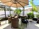 Screened patio with outdoor seating, umbrella, and lush plants, perfect for relaxing at 1311 Fallwood Dr, Deltona, FL 32725