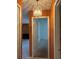 Hallway features a chandelier, orange walls and tile floor, leading to rooms at 132 Wax Myrtle Ct, Sanford, FL 32773