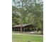 Large picnic shelter with multiple tables and benches surrounded by mature trees and a winding sidewalk at 132 Wax Myrtle Ct, Sanford, FL 32773