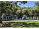 A colorful playground with slides, swings, and climbing structures surrounded by lush greenery at 132 Wax Myrtle Ct, Sanford, FL 32773