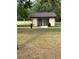 Small restroom building with a brown tile roof and exterior access stalls in a grassy field at 132 Wax Myrtle Ct, Sanford, FL 32773