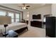 Calm bedroom with large windows and a ceiling fan, featuring neutral walls and dark wood furniture for a relaxing retreat at 133 Azure Mist Way, Daytona Beach, FL 32124