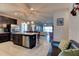 Open-concept kitchen with dark cabinetry, stainless steel appliances, a kitchen island, and views into the living area at 133 Azure Mist Way, Daytona Beach, FL 32124