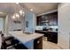 An open kitchen featuring dark wood cabinets, stainless steel appliances, and a large island with bar seating at 133 Azure Mist Way, Daytona Beach, FL 32124