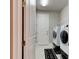 Modern laundry room with a front-load washer and dryer, storage shelves, and a sleek black laundry mat at 133 Azure Mist Way, Daytona Beach, FL 32124
