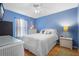Comfortable bedroom with blue walls, wood floor, and a ceiling fan at 133 Brasswood Ct, Daytona Beach, FL 32117