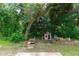 Large backyard with a playhouse surrounded by mature trees and greenery at 1388 15Th St, Orange City, FL 32763