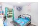 Well-lit bedroom decorated with toys, blue accents, and wood-look flooring at 1388 15Th St, Orange City, FL 32763