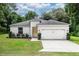 Charming single-story home featuring a gray exterior, complemented by a two car garage and well-manicured landscaping at 1388 15Th St, Orange City, FL 32763
