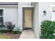 Inviting front entryway with a bright yellow door, manicured bushes, and decorative outdoor lighting at 1388 15Th St, Orange City, FL 32763