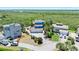 Aerial view of a blue house surrounded by lush greenery near a scenic body of water at 14 Marsh Ct, Ponce Inlet, FL 32127