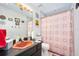 Modest bathroom featuring a pink sink, decorative shower curtain, and linoleum flooring at 14 Marsh Ct, Ponce Inlet, FL 32127