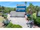 Bright blue home with a three-car garage and lush landscaping at 14 Marsh Ct, Ponce Inlet, FL 32127