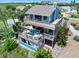 Exterior of a multi-level home with a large deck and screened-in area with outdoor seating at 14 Marsh Ct, Ponce Inlet, FL 32127