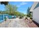 Charming front yard with mature trees, a blue fence and gravel beds, and a walkway to the house at 14 Marsh Ct, Ponce Inlet, FL 32127