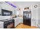 Well-lit kitchen featuring ample countertop space, white cabinets, and modern black appliances at 14 Marsh Ct, Ponce Inlet, FL 32127