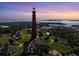 Scenic aerial view of the Ponce de Leon Inlet Lighthouse against a colorful sunset at 14 Marsh Ct, Ponce Inlet, FL 32127