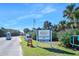 Entrance to Lighthouse Point Park, featuring lush greenery, signage, and an American flag waving in the breeze at 14 Marsh Ct, Ponce Inlet, FL 32127