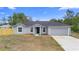 Charming gray single-story home featuring an attached garage and a well-maintained lawn at 1435 6Th Ave, Deland, FL 32724