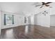 Bright living room features wood floors, white walls, a ceiling fan and a decorative compass at 1435 6Th Ave, Deland, FL 32724