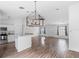 Spacious living room with wood floors and modern light fixture, open to the kitchen with a breakfast bar at 1435 6Th Ave, Deland, FL 32724