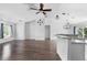 Bright living room features wood floors, white walls, a ceiling fan and a granite counter kitchen area at 1435 6Th Ave, Deland, FL 32724