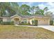 Charming single-story home with a well-manicured lawn, mature trees, and attached two-car garage at 1450 14Th St, Orange City, FL 32763