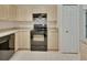 Clean kitchen with neutral cabinetry, black appliances, and tiled flooring for easy maintenance at 1450 14Th St, Orange City, FL 32763