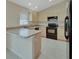 Functional kitchen featuring classic cabinetry, tile floors, and modern black appliances at 1450 14Th St, Orange City, FL 32763
