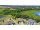 An aerial view shows a private home surrounded by lush greenery, neighboring houses, and tranquil ponds at 1480 Leitrim Loop, Apopka, FL 32703