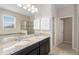 Well-lit bathroom featuring double vanity, granite counters, large mirror, and a glass shower at 1480 Leitrim Loop, Apopka, FL 32703