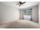 Cozy bedroom with neutral carpet, ceiling fan, and window with sheer blue curtains at 1480 Leitrim Loop, Apopka, FL 32703