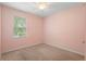 This bedroom features carpet, pink walls, a window with blinds, and a ceiling fan at 1480 Leitrim Loop, Apopka, FL 32703