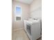 Bright laundry room featuring tile floors, a window, and a full-size washer and dryer at 1480 Leitrim Loop, Apopka, FL 32703