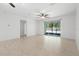Large, airy living room featuring neutral tile flooring and sliding glass doors to an outdoor space at 1480 Leitrim Loop, Apopka, FL 32703